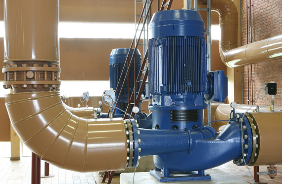 Industrial blue pump connected to large brown pipes in a facility.